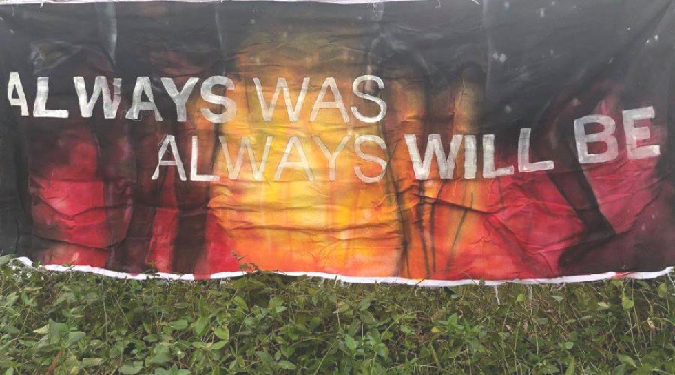Banner at Djab Wurrung Protection Embassy with Aboriginal colours says "always was, always will be" and grass in foreground