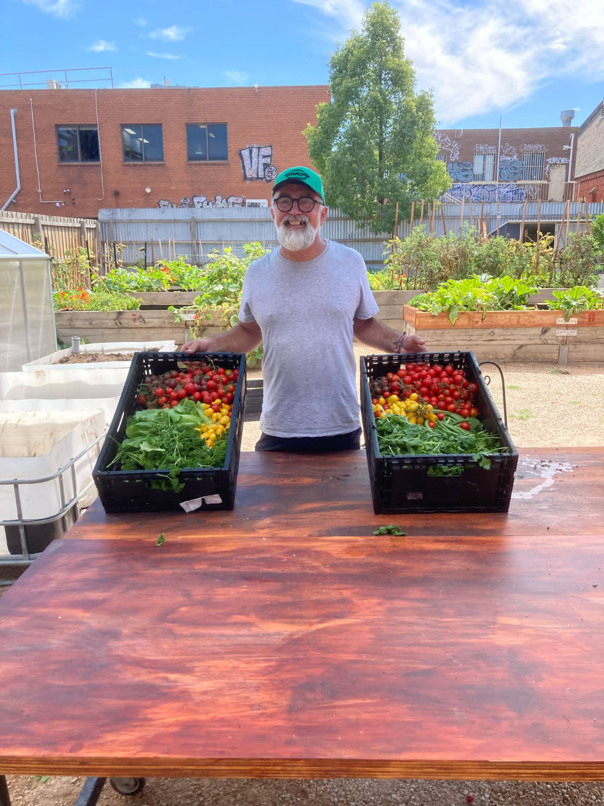 Peter Gartside at the Footscray Community Garden and Learning Place with boxes of fresh produce.