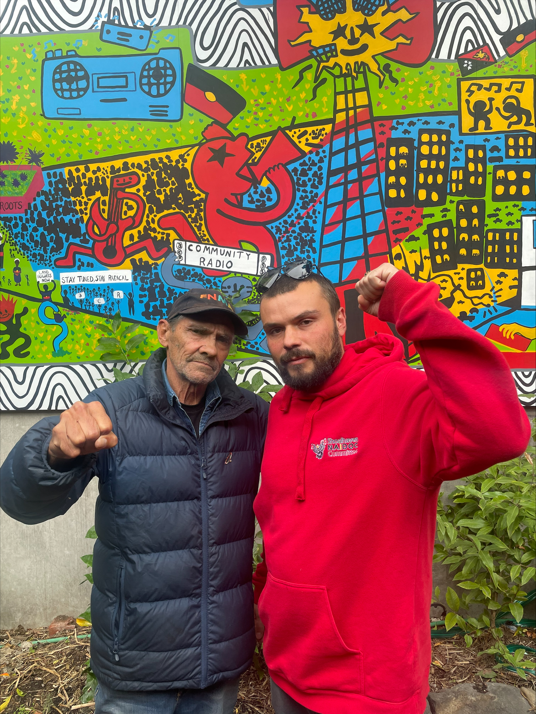 Keiran Stewart-Assheton and Djuran Bunjileenee Robbie Thorpe in the 3CR garden, raising their fists