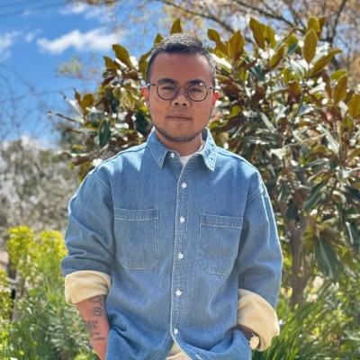 Man dark hair dark-rimmed glasses blue denim shirt very trimmed beard