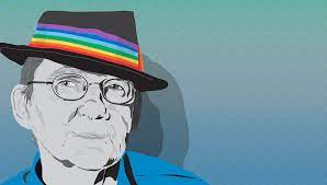 person with glasses and rainbow -coloured hatband on tophat