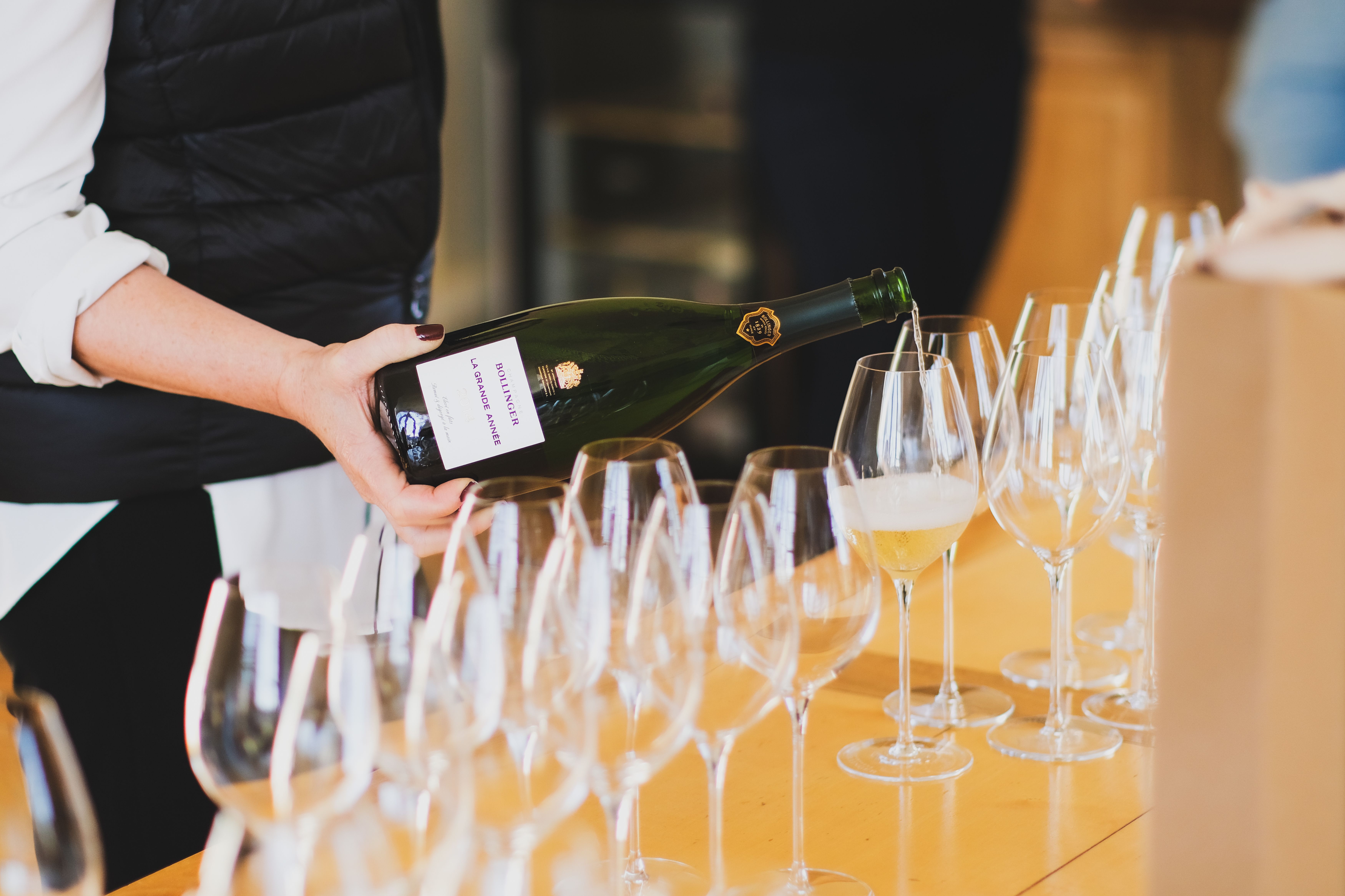 A person pours champagne in a glass