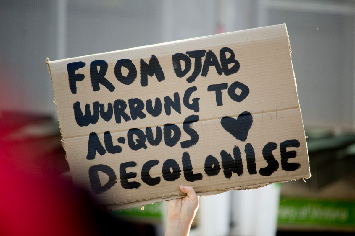 Image: a sign fro a protest reads 'From Djab Wurrung to Al-Quds, Decolonise'. The words a written on plain cardboard in black ink. The image was taken at the Free Palestine protest in Naarm on May 22, 2021