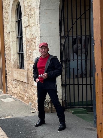 Image of man standing outside Adelaide prison. He faces the camera smiling