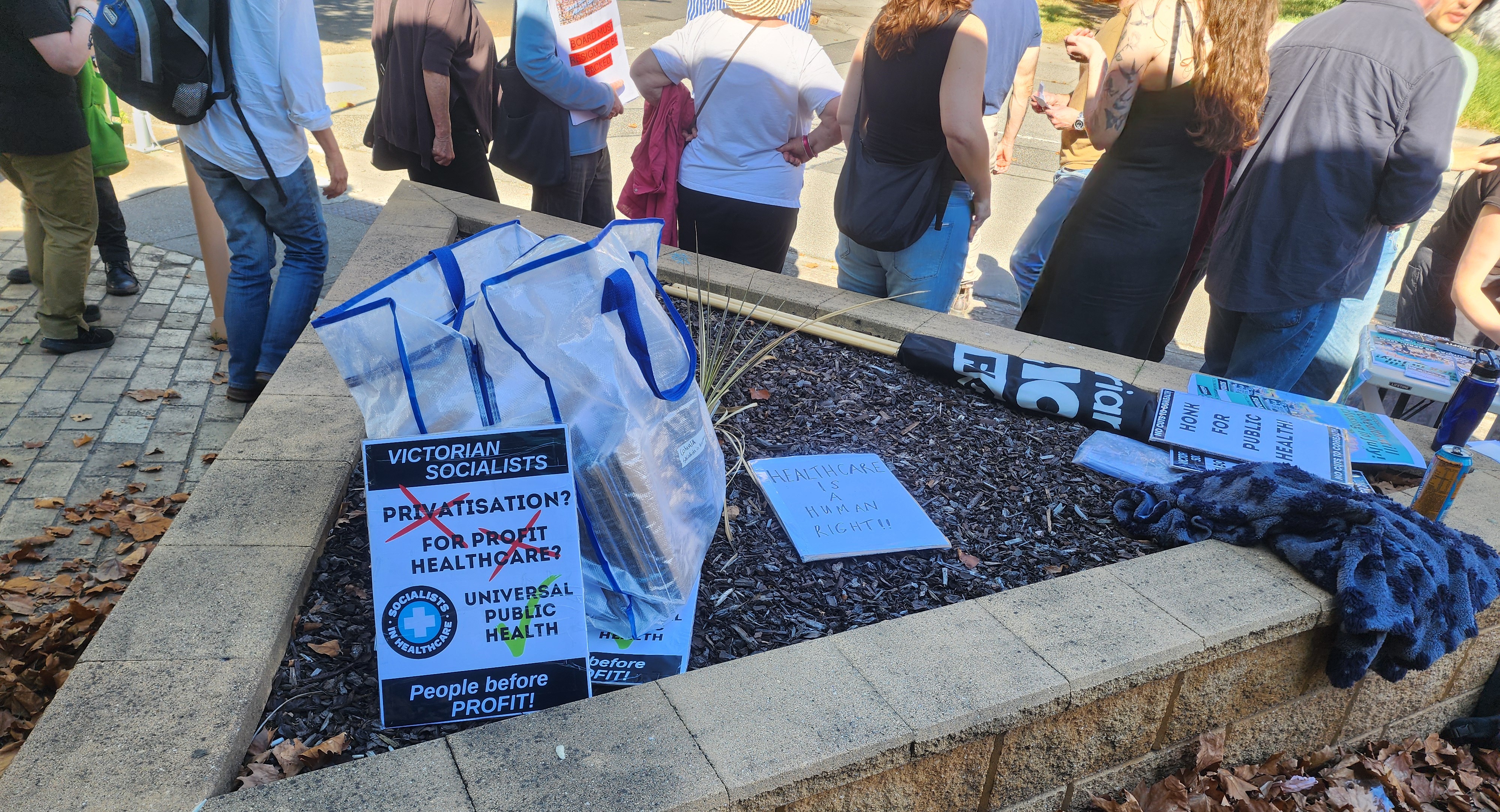 Photograph from Save Cohealth Rally Sunday 26th April 2026 at Collingwood Cohealth, Naarm. Text reads: "Privatisation, For Profit Healthcare (X) Universal Public Health (Tick). People before Profit."