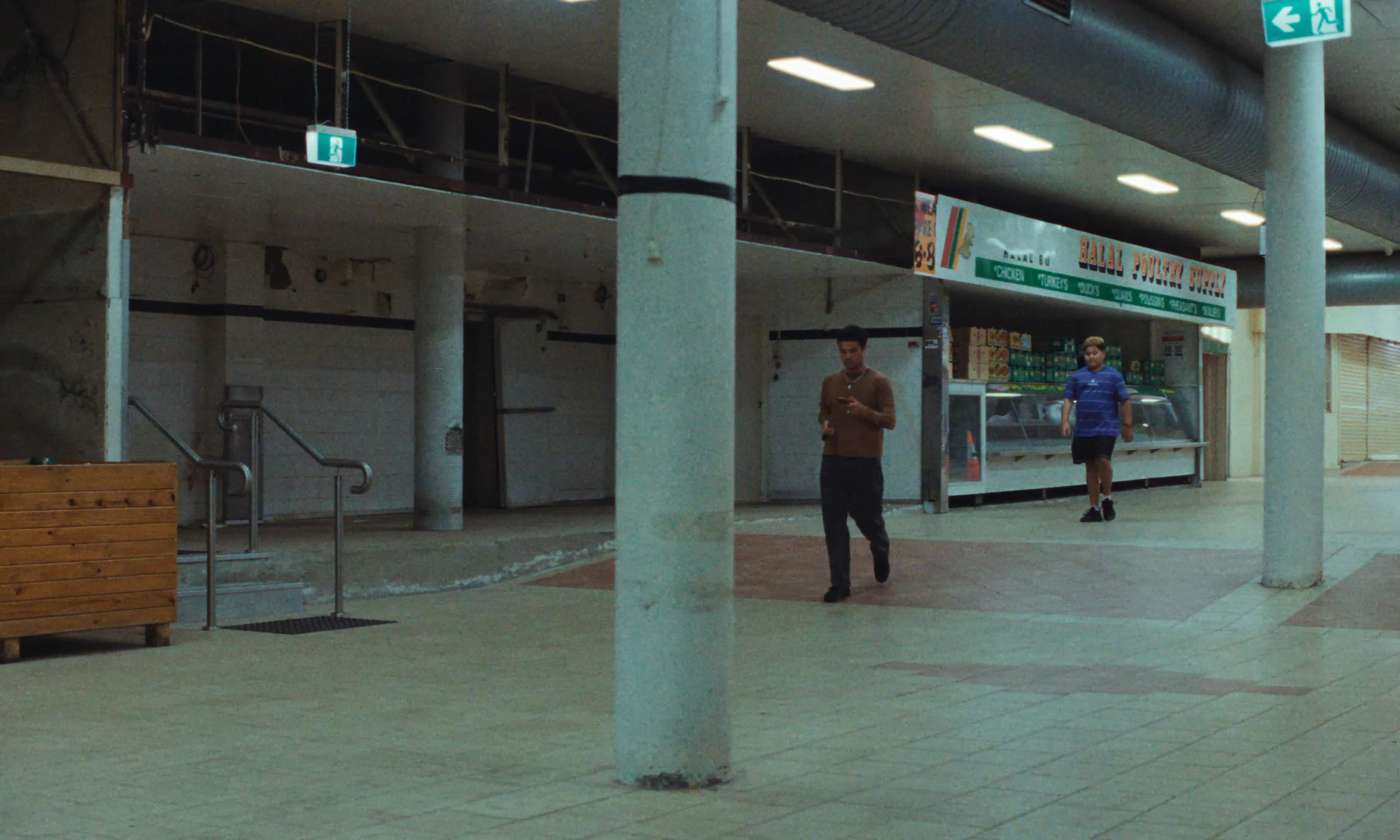 Tiaki and Samson starring in Stranger, Brother, walking through an empty shopping mall. 