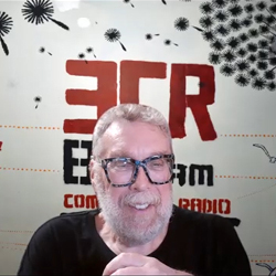 Indigenous Elder Uncle Paul sitting in front of 3CR Studio Wall