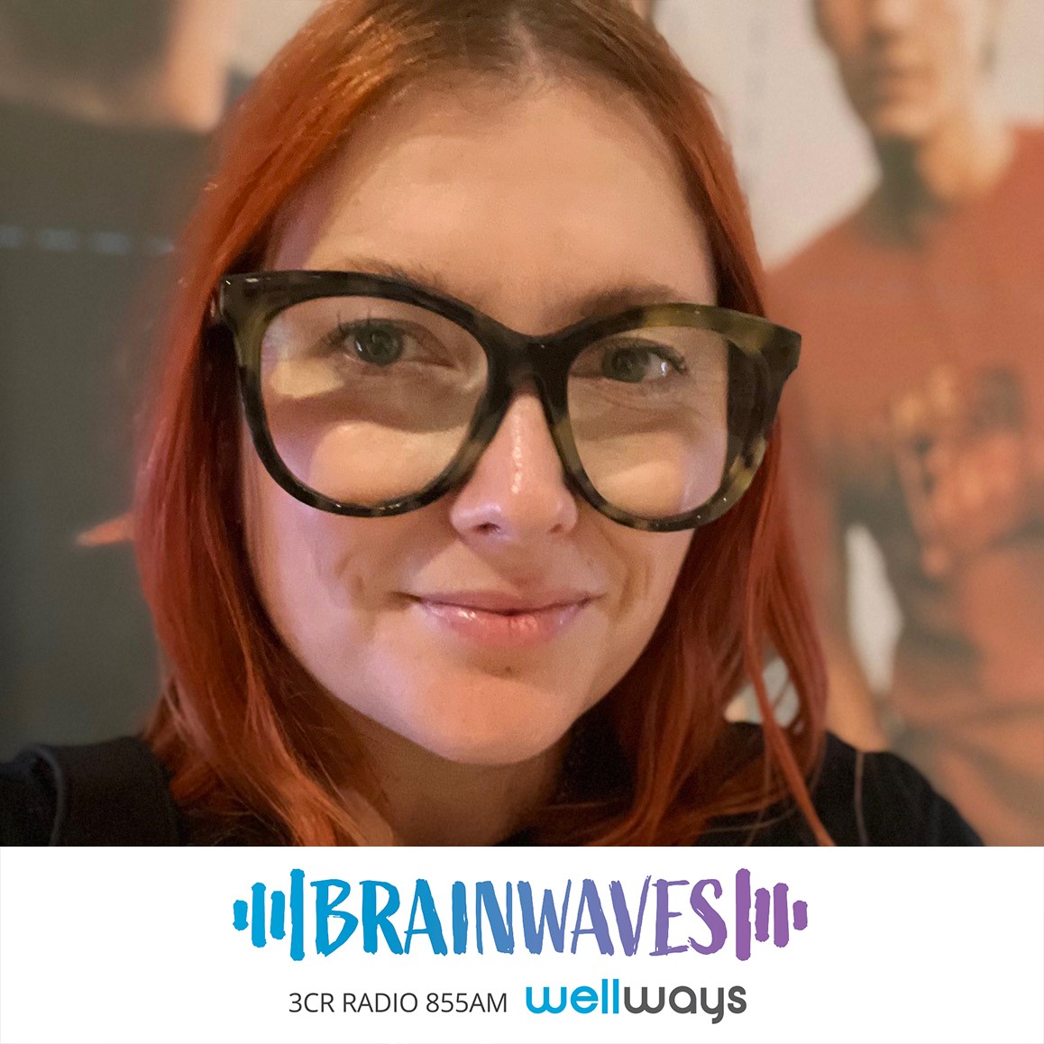 Cassie Walker is a caucasian woman with bright red shoulder length hair, she has large black-rimmed glasses and is wearing a black top. She looks at the camera a smirks. The brainwaves logo is in blue and purple and is placed at the bottom of the image. Cassie is today's guest on Brainwaves talking about mental health and the music industry.