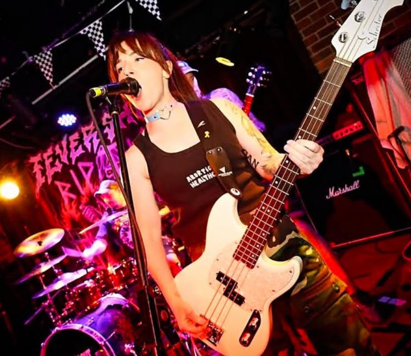 Photo of Meg playing bass guitar