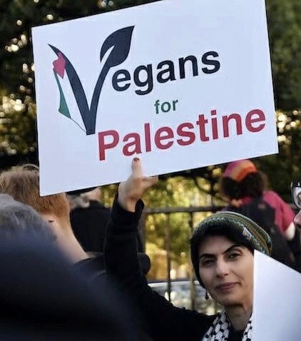 Photo of Dr Leila Dehghan holding a sign which says Vegans for Palestine at a solidarity rally