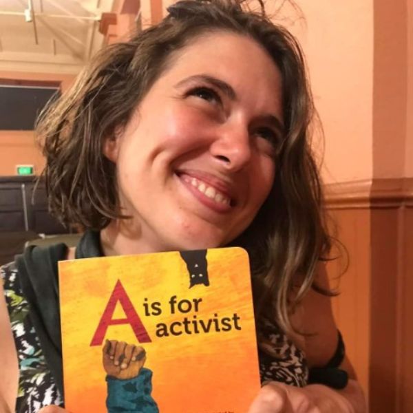 Violet Coco holding a book call A is for activist