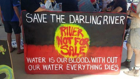 Banner of Aboriginal flag saying 'Save the Darling River; River not for sale; Water is our blood, without water everything dies'