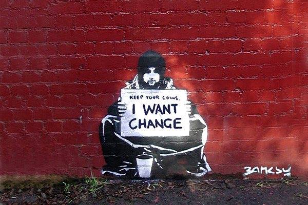 Graffiti showing a presumably homeless person with a sign reading 'Keep your coins, I want change'