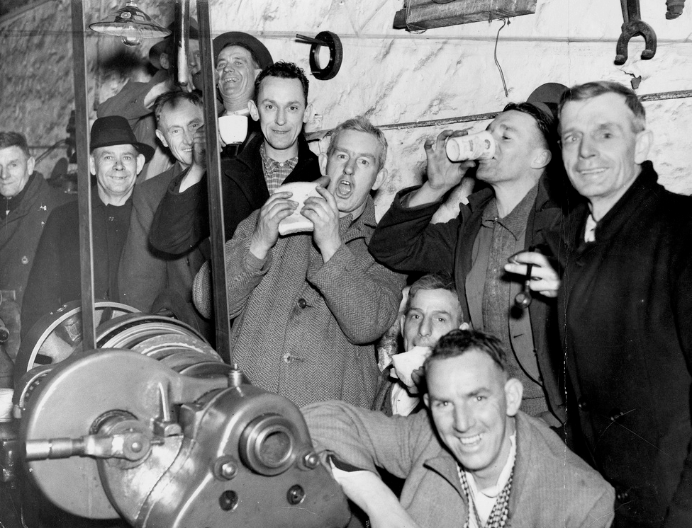 A group of workers stand around in an occupied workplace in 1937.