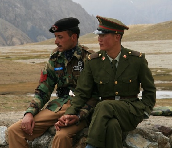 Chinese and Pakistani border guards holding hands