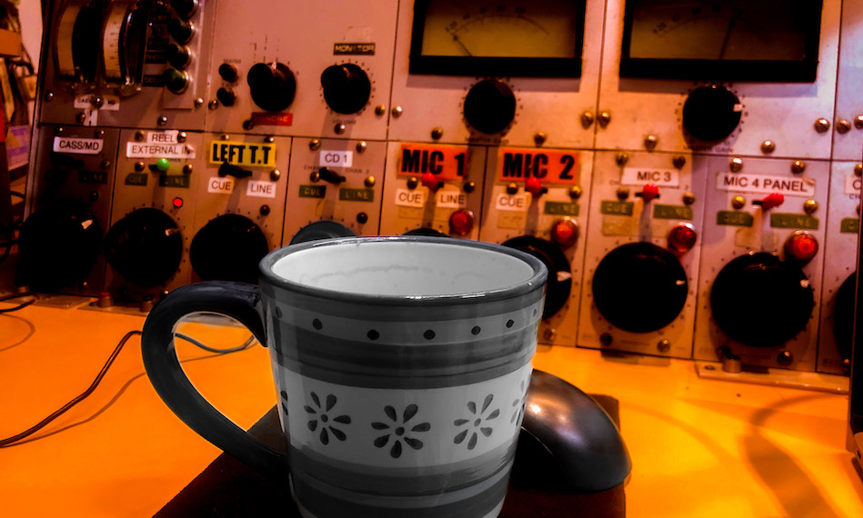 A cup in the foreground of 3CR studio panel