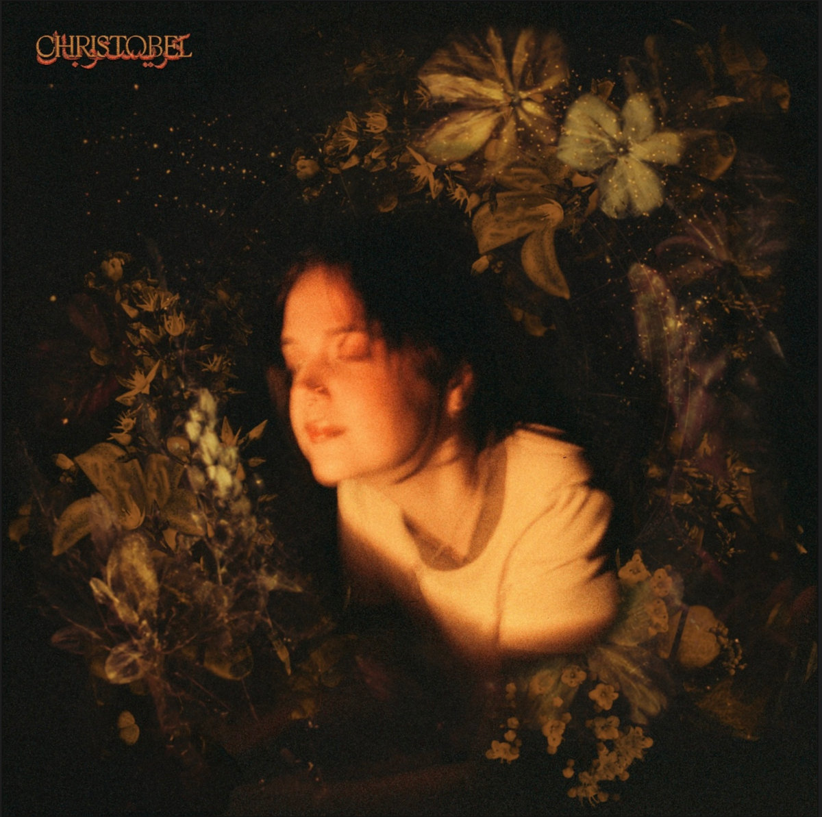 The album artwork for GLOW by Christobel, featuring a sepia toned image of a woman with her eyes closed surrounded by a wreath of flowers 