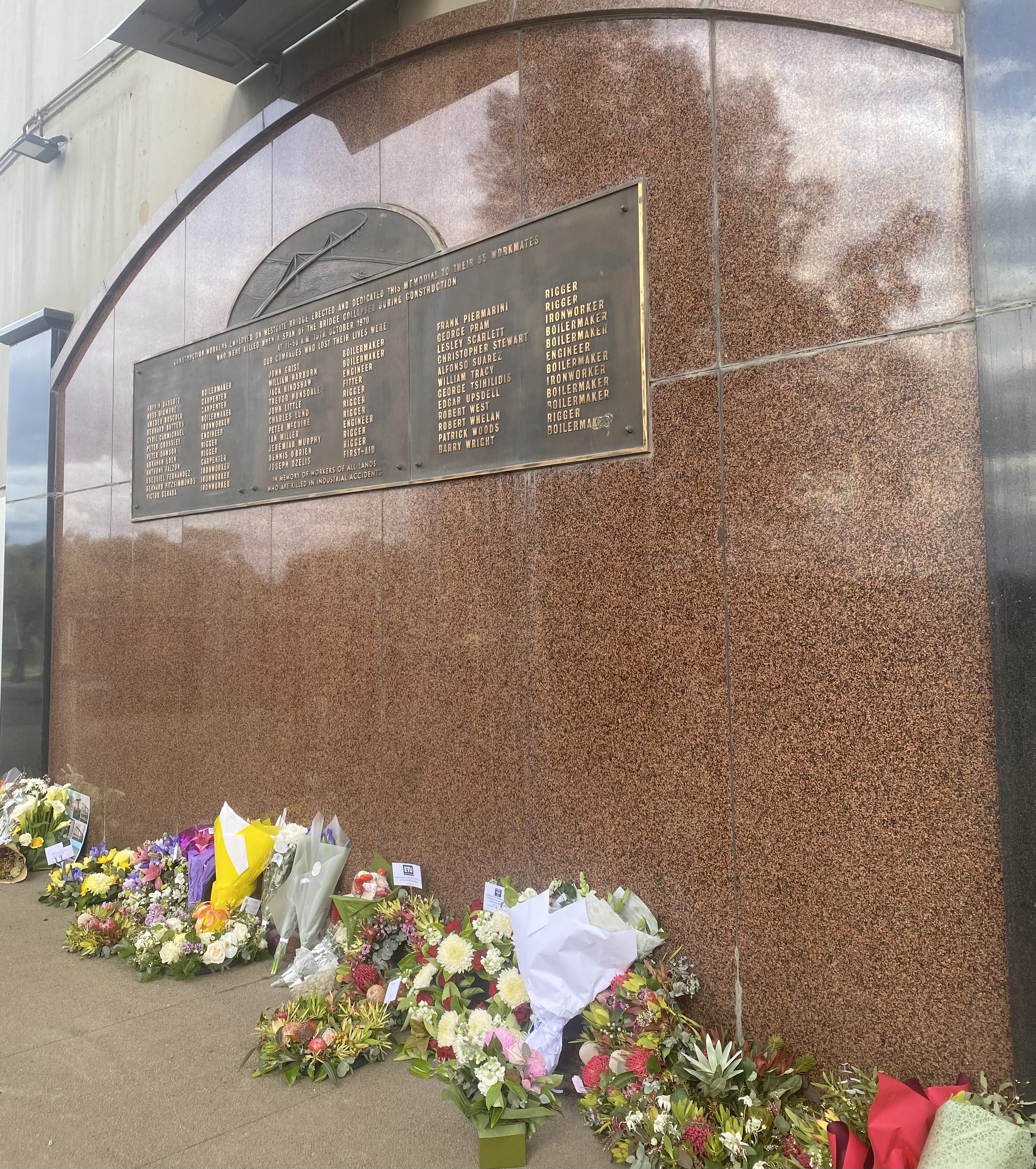 Memorial plaque on the Westgate bridge (paid for and erected by fellow workers of the victims), with flowers and tributes from the 2022 memorial service.