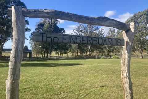 A wooden sign made of logs with "The Fingerboards" written on it. 