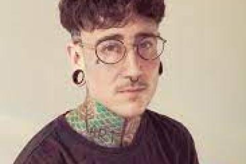 Julz Evans masculine presenting person short dark hair glasses tattoo on neck