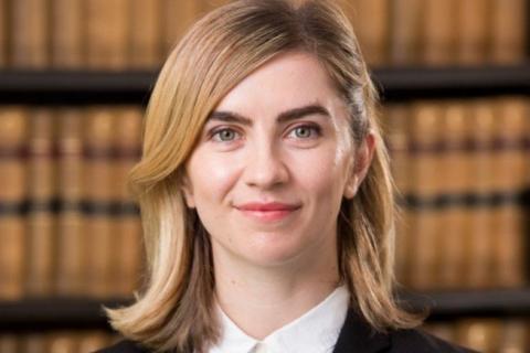 Nevena Spirovski law books in background, black  jacket, white blouse