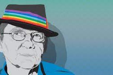 person with glasses and rainbow -coloured hatband on tophat