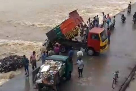 Truck dumps rubbish into a river