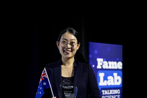 Tammy Lee holding an Australian flag and FameLab trophy
