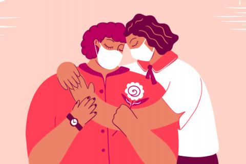 Two masked people share a hug