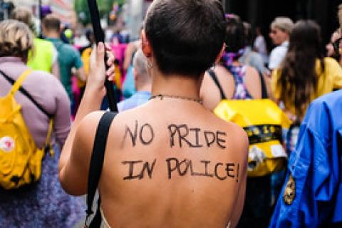 A person's back with 'No Pride in Police' written on it