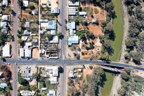 An aerial photograph of Wilcannia looking directly down on the town. Part of the town centre's street grid is visible, as well as the road bridge over the Darling River.