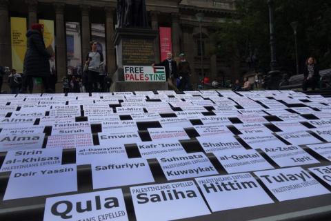 A photograph of the steps of Victoria's State Library, which are covered in rows of signs with the names of villages destroyed in the Nakba.