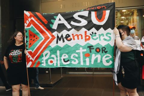 ASU Members for Palestine Banner at worker's strike on Thu 22 Feb 2024. Two people hold up read black, white, and green banner in bold font reading ASU members for Palestine. 