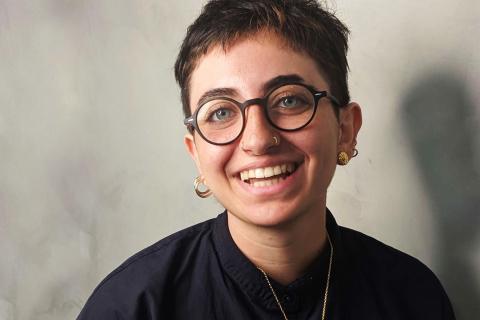 Image of a smiling person, with short dark hair and glasses. The guest presenter of 3CR Spoken Word, Lujayn Hourani