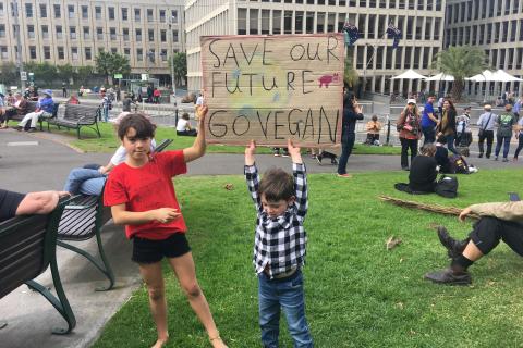 Kids holding up sign that reads, 'Save our Future, Go Vegan'.