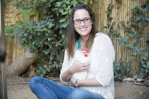 Photo of Ondine smiling with a rescue hen. Photo provided by Ondine Sherman. 