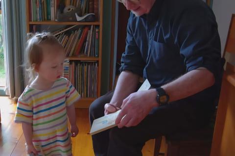 Photo of Chris reading to his niece. Photo supplied by Tim Rust. 