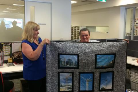 Edna, a life member of the CFMEU, on the right getting her favourite possession her crane quilt