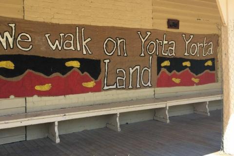 Large banner reading "We walk on Yorta Yorta land" hung on a wall