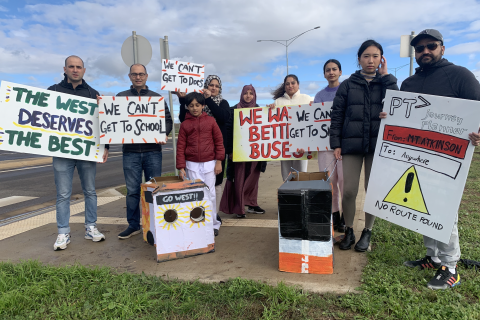 Image of community members from Mt.Atkinson holding signs saying 'Better Buses for the West', 'We can't get to school', 'We can't get to docs', 'We want Better Buses', 'We can't get to shops' and 'PTV journey planner from Mt. Atkinson to Anywhere'