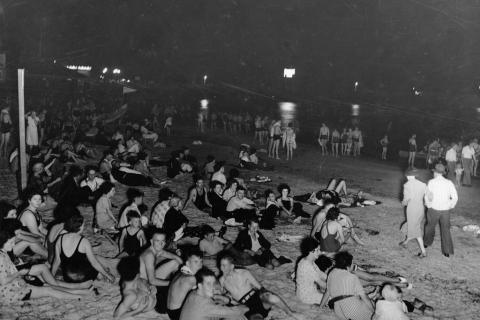 View of Glenelg Beach taken on a hot February night showing bathers seeking relief from the heat.