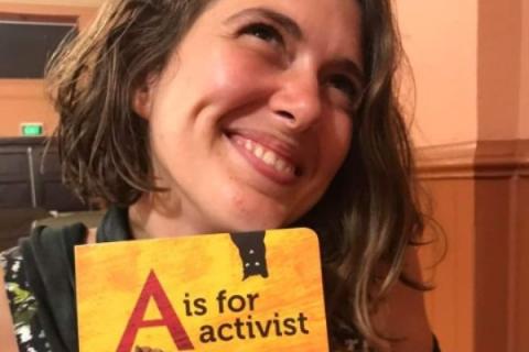 Violet Coco holding a book call A is for activist