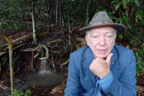 Dr Corkill by a creek at a Rotary Park rainforest reserve, Lismore. 