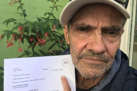 Djuran Bunjileenee Robbie Thorpe holding an affidavit in the 3CR garden
