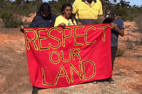 Aunty Sue Haseldine and family with 'Respect Our Land' banner at Little Inla rockhole.