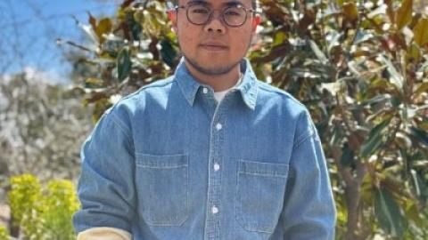 Man dark hair dark-rimmed glasses blue denim shirt very trimmed beard