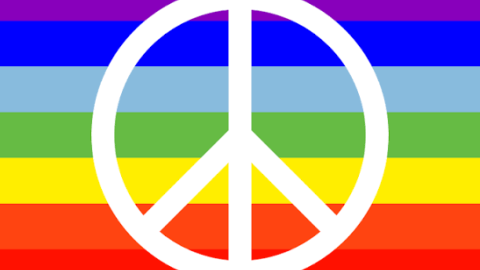 white peace symbol over rainbow colours