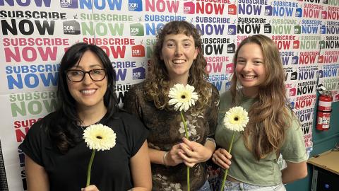 Photo of Jennifer, Savanna and Elise in the 3CR studio, each holding a flower.