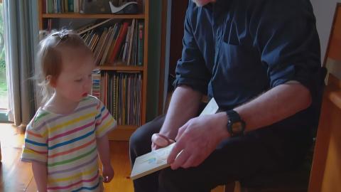 Photo of Chris reading to his niece. Photo supplied by Tim Rust. 