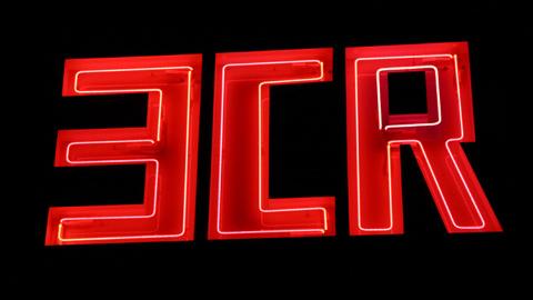 A close-up photograph of an illuminated Neon sign which reads 3CR, taken at night time.